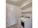 Well-lit laundry room with a washer, dryer, shelving, and a door to the outside at 5778 W Corrine Dr, Glendale, AZ 85304