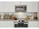 Close-up of stainless steel oven, microwave, subway tile, granite counter, and kitchen appliances at 6541 N 41St Ave, Phoenix, AZ 85019