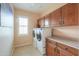 Inside view of laundry room with washer and dryer, built-in cabinets, countertops, tile floors, and window at 682 W Rambler Ct, Casa Grande, AZ 85122