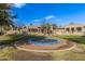 Large backyard with a sunken trampoline, landscaping and views of the house, outdoor fireplace and other back yard amenities at 7215 W Union Hills Dr, Glendale, AZ 85308
