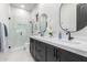 Bathroom featuring dual sinks, marble countertop, walk-in shower, modern faucets and beautiful vanity mirrors at 7215 W Union Hills Dr, Glendale, AZ 85308