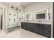 Modern bathroom boasts a glass-enclosed shower, dual sinks, and well-lit mirrors for a luxurious feel at 7215 W Union Hills Dr, Glendale, AZ 85308
