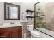 Bathroom features tiled shower, modern toilet, dark wood vanity and framed mirror for updated comfort at 7215 W Union Hills Dr, Glendale, AZ 85308