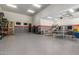 Large garage featuring high ceilings, game tables, storage solutions, and stainless steel refrigerator at 7215 W Union Hills Dr, Glendale, AZ 85308