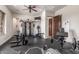 Spacious home gym with ceiling fan, mounted TV and various exercise equipment at 7215 W Union Hills Dr, Glendale, AZ 85308
