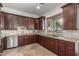 Gourmet kitchen featuring stainless appliances, dark wood cabinets, and granite countertops at 7215 W Union Hills Dr, Glendale, AZ 85308