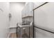 Modern laundry room with stainless steel washer and dryer, and overhead storage cabinets at 7215 W Union Hills Dr, Glendale, AZ 85308