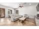 Open-plan living room with neutral decor, travertine floors, and ceiling fan at 7215 W Union Hills Dr, Glendale, AZ 85308