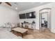 Bright living room featuring travertine floors, white leather furniture, and adjacent home gym at 7215 W Union Hills Dr, Glendale, AZ 85308