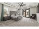 A primary bedroom features a trey ceiling, a ceiling fan and a seating area near the French doors at 7215 W Union Hills Dr, Glendale, AZ 85308