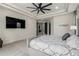 Spacious main bedroom featuring neutral tones, a ceiling fan, and a mounted television for comfortable living at 7215 W Union Hills Dr, Glendale, AZ 85308