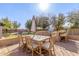 Outdoor dining area with a wooden table, chairs, umbrella, built-in grill, and lush landscaping at 7215 W Union Hills Dr, Glendale, AZ 85308