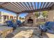 Cozy outdoor fireplace area with comfortable seating, stone accents, and lush greenery at 7215 W Union Hills Dr, Glendale, AZ 85308