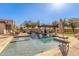 Backyard oasis featuring a sparkling pool, outdoor kitchen, and covered seating area with lush landscaping at 7215 W Union Hills Dr, Glendale, AZ 85308