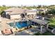 Resort-style backyard boasts a sparkling pool, a pergola-covered seating area, and an outdoor kitchen, perfect for entertaining at 7215 W Union Hills Dr, Glendale, AZ 85308