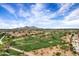 Stunning aerial view of a golf course community with lush fairways, blue sky and mountain views at 7818 E Cactus Wren Rd, Scottsdale, AZ 85250
