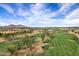 Overhead view of a community and golf course in a desert setting with distant mountain views at 7818 E Cactus Wren Rd, Scottsdale, AZ 85250