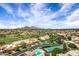 Beautiful aerial view of a desert community with a golf course, community pool, and tennis courts at 7818 E Cactus Wren Rd, Scottsdale, AZ 85250