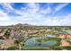Community aerial shot, showcasing a golf course, lakes, and condos, all framed by desert mountains at 7818 E Cactus Wren Rd, Scottsdale, AZ 85250