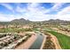 Scenic aerial view of a golf course community featuring lush landscaping, lakes, and stunning mountain views at 7818 E Cactus Wren Rd, Scottsdale, AZ 85250