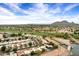 Scenic aerial view of a golf course community featuring lush landscaping, lakes, and stunning mountain views at 7818 E Cactus Wren Rd, Scottsdale, AZ 85250
