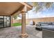 Covered patio with a column, a gray wicker sectional sofa, and a Traeger grill on a paver patio, perfect for entertaining at 7818 E Cactus Wren Rd, Scottsdale, AZ 85250