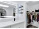 Bright bathroom showcasing an illuminated mirror, modern vanity, and a well-organized walk-in closet at 7818 E Cactus Wren Rd, Scottsdale, AZ 85250