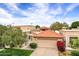 Charming home with a terracotta tile roof, manicured lawn, and mature trees, exuding curb appeal and character at 7818 E Cactus Wren Rd, Scottsdale, AZ 85250