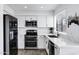 Modern kitchen featuring stainless steel appliances, white cabinets, and a large window at 7818 E Cactus Wren Rd, Scottsdale, AZ 85250