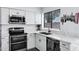Stylish kitchen with stainless steel appliances, white cabinets, and a view to the backyard at 7818 E Cactus Wren Rd, Scottsdale, AZ 85250