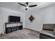 Cozy living room featuring gray carpet, modern ceiling fan, and a mounted television for entertainment at 7818 E Cactus Wren Rd, Scottsdale, AZ 85250