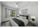 Staged bedroom with neutral carpet, ceiling fan, large window, and stylish furniture at 839 S Westwood Rd # 253, Mesa, AZ 85210