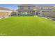 Spacious backyard with lush artificial turf, a built-in outdoor kitchen, and a privacy fence at 842 E Beverly Rd, Phoenix, AZ 85042