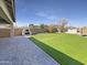 Landscaped backyard featuring well-maintained artificial grass, a pizza oven, and a low rock wall at 842 E Beverly Rd, Phoenix, AZ 85042