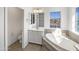 Sunlit bathroom featuring a soaking tub, vanity with mirror, and tile flooring for a luxurious feel at 842 E Beverly Rd, Phoenix, AZ 85042