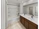 Well-lit bathroom featuring double sinks, a large mirror, and a shower-tub combo for comfort at 8886 S 256Th Dr, Buckeye, AZ 85326