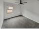 Bedroom featuring a ceiling fan, gray carpet, and large window with natural light at 8886 S 256Th Dr, Buckeye, AZ 85326
