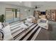 Bright living room featuring neutral decor, plush seating, and sliding glass doors to the backyard at 8886 S 256Th Dr, Buckeye, AZ 85326