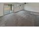 Spacious, well-lit living room with plush carpet and sliding glass doors leading to the backyard at 8886 S 256Th Dr, Buckeye, AZ 85326