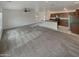Open living room featuring a ceiling fan, carpeted floors, and a modern kitchen at 8886 S 256Th Dr, Buckeye, AZ 85326