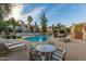 Community pool area with lounge chairs and table with seating under the bright sky at 9711 E Mountain View Rd # 2524, Scottsdale, AZ 85258