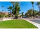 The Racquet Club entrance with lush landscaping, mature palm trees, and a welcoming sign at 9711 E Mountain View Rd # 2524, Scottsdale, AZ 85258
