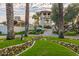 Inviting entrance to The Racquet Club with vibrant flower beds and mature palm trees at 9711 E Mountain View Rd # 2524, Scottsdale, AZ 85258