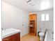 Functional bathroom with storage shelving, a white toilet and a vintage vanity at 100 Swilling Ave, Wickenburg, AZ 85390