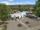 Aerial view of a cozy single Gathering house with mature landscaping and desert surroundings at 100 Swilling Ave, Wickenburg, AZ 85390