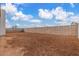 Spacious dirt backyard area enclosed with a block wall, set against a bright blue sky at 10302 E Utah Ave, Mesa, AZ 85212