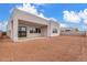 Exterior view of backyard with patio and sliding glass doors with dirt landscaping at 10302 E Utah Ave, Mesa, AZ 85212