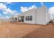 Exterior view of home's back facade featuring a patio, windows and dirt landscaping at 10302 E Utah Ave, Mesa, AZ 85212