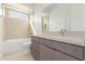 Modern bathroom features a shower-tub combo, neutral tile, and a sleek gray vanity at 10302 E Utah Ave, Mesa, AZ 85212