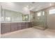 Modern bathroom featuring a double sink vanity, large mirror, and glass-enclosed shower for a spa-like experience at 10302 E Utah Ave, Mesa, AZ 85212